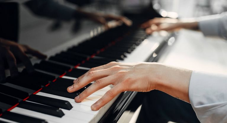 Hände spielen auf einem Klavier