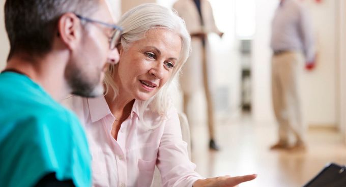 Therapeut und ältere Patienten lesen am Tablet