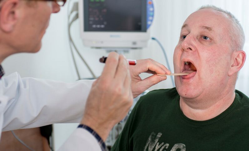 Arzt untersucht Rachen eines Patienten