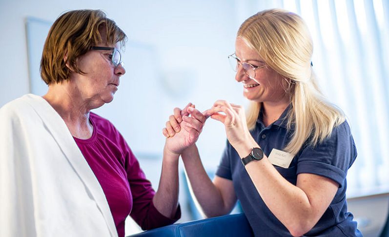 Therapeutin behandeln Finger einer Patientin