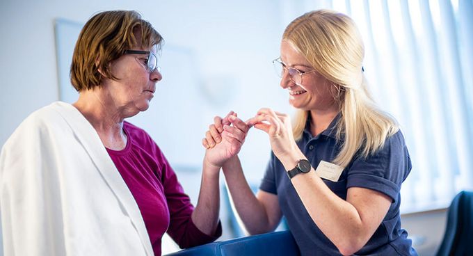 Therapeutin behandeln Finger einer Patientin