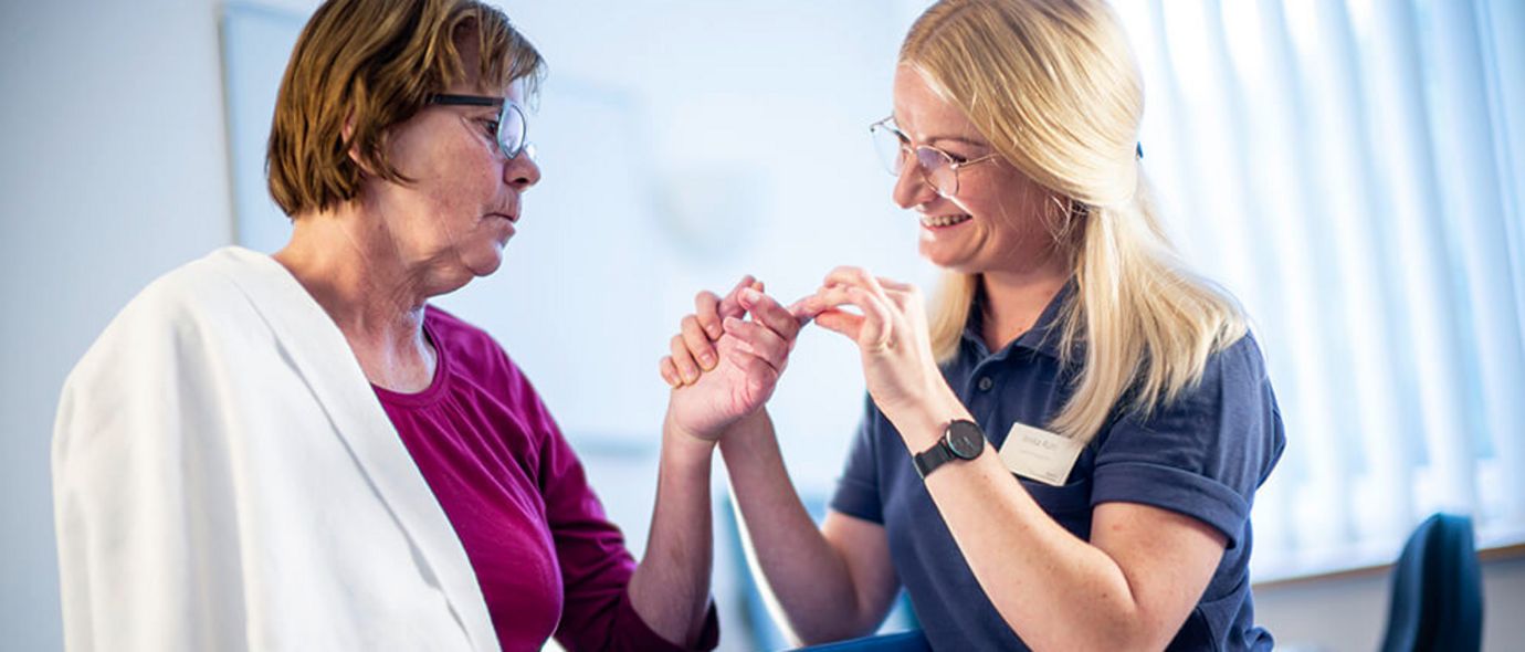 Therapeutin behandeln Finger einer Patientin