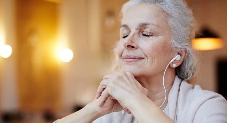 Frau hört mit geschossenen Augen Musik