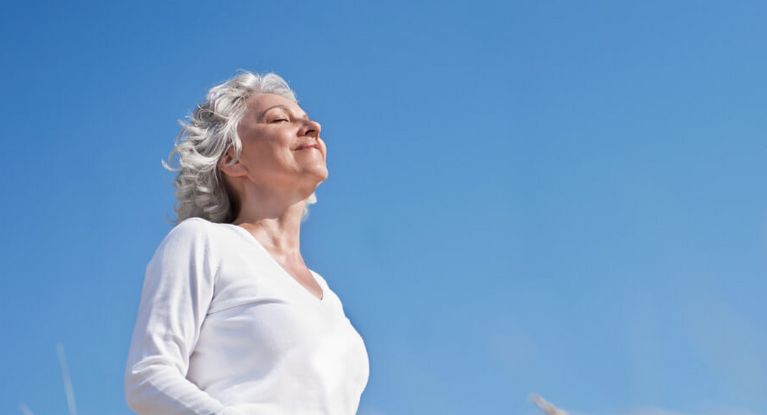 Grauhaarige Seniorin entspannt in der Sonne