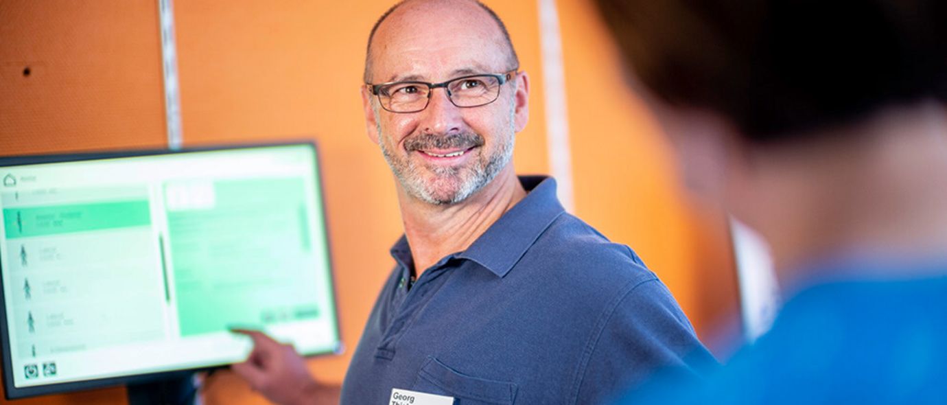 Therapeut erklärt Patienten Ergebnisse am Monitor