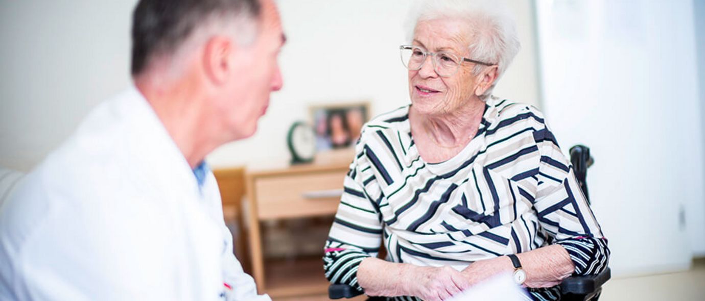 Arzt spricht mit älterer Patientin
