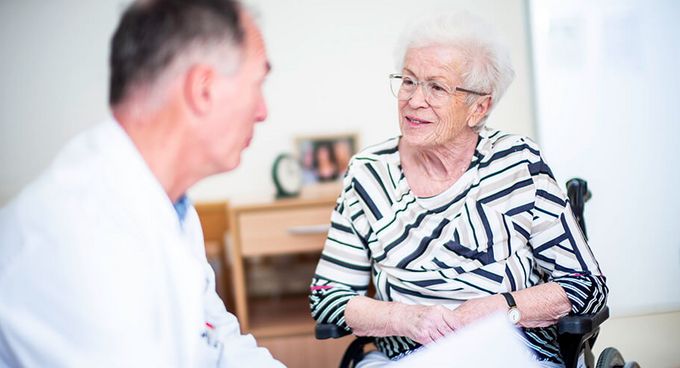 Arzt spricht mit älterer Patientin