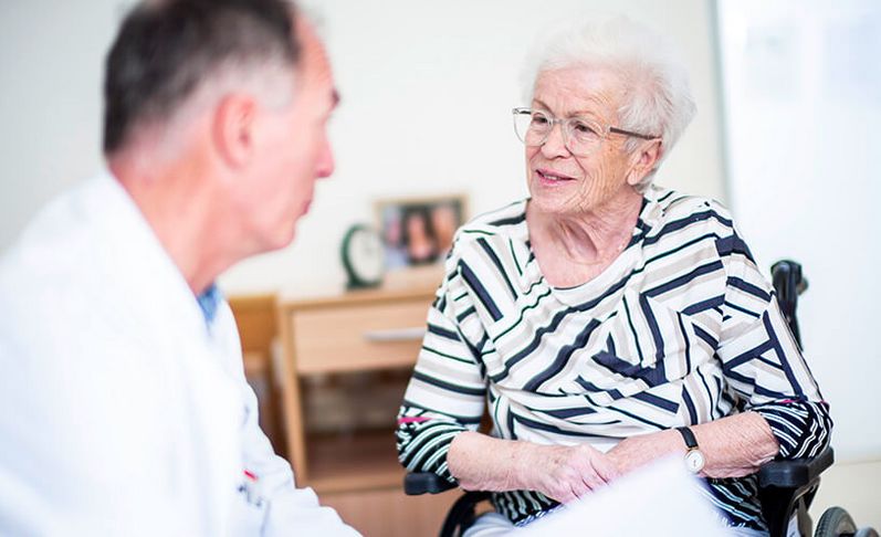Arzt spricht mit älterer Patientin
