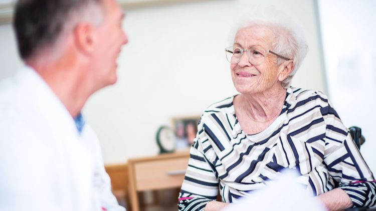 Arzt spricht mit älterer Patientin
