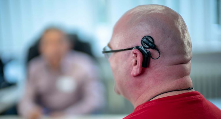 Patient mit Cochlea Implantat spricht mit Ärzten
