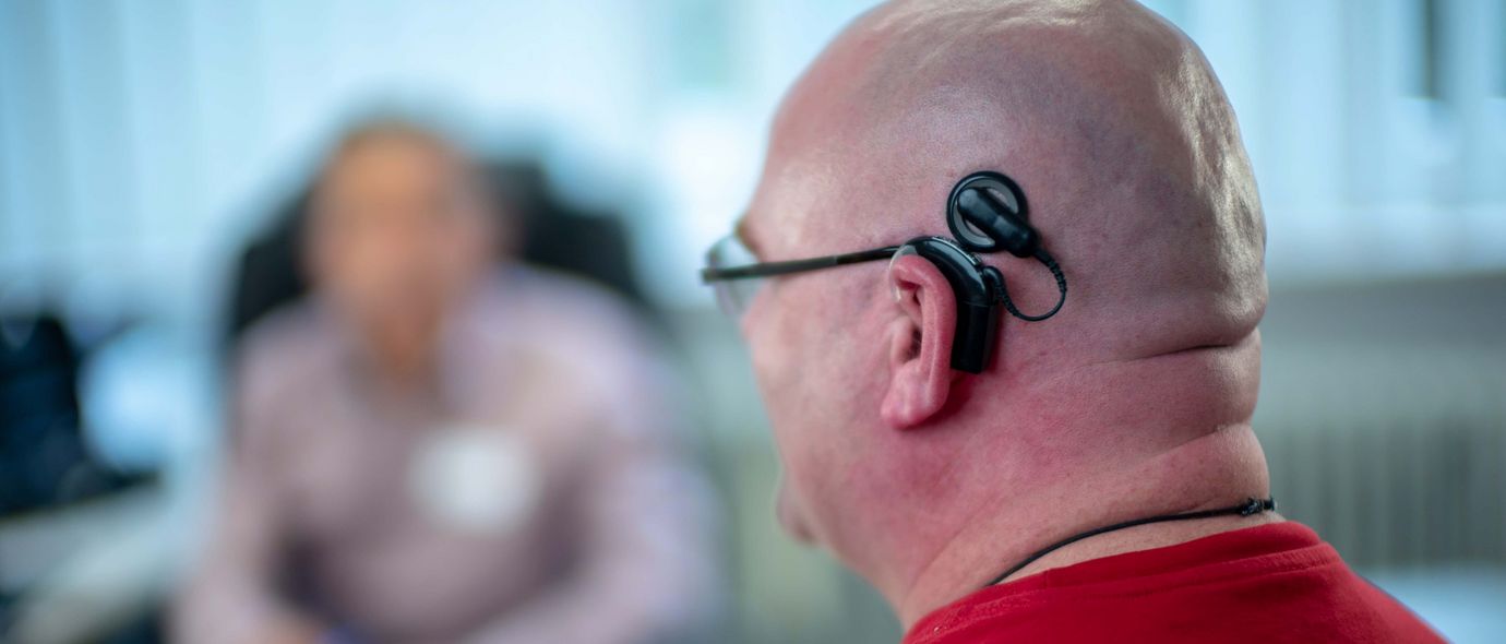 Patient mit Cochlea Implantat spricht mit Ärzten
