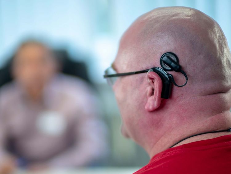 Patient mit Cochlea Implantat spricht mit Ärzten