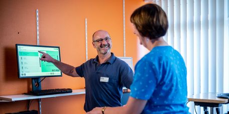 Thrapeut erklärt Patientin Ergebnisse auf einem Bildschirm